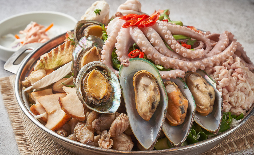 Fresh octopus, mussels and abalone in the pan